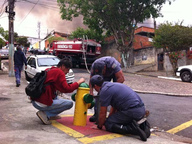 Bombeiros trabalham para abrir hidrante em rua vizinha ao incêndio (Foto: Paulo Toledo Piza/G1)