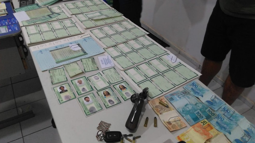 Dupla é presa com 143 cédulas para falsificação de documentos falsos e uma arma de fogo — Foto: Lucas Pessoa/G1