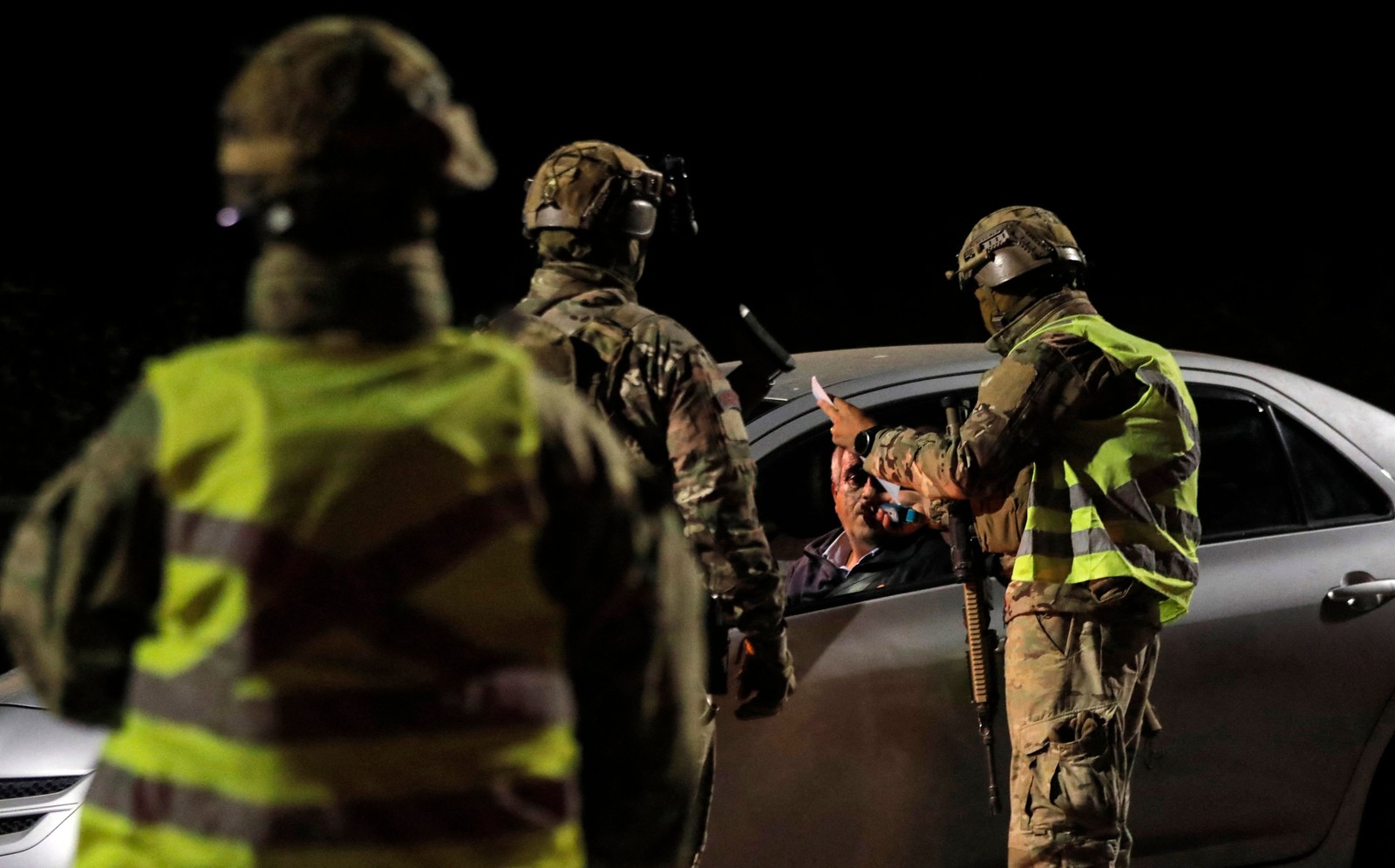 Militares chilenos verificam veículos em um posto de controle de segurança durante toque de recolher na zona de incêndio florestal em Tomé, região sul do Chile — Foto: JAVIER TORRES/AFP