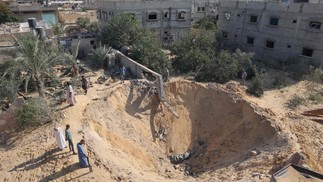 Palestinos inspecionam cratera após os últimos três dias de conflito com Israel antes de uma trégua, na cidade de Rafah, no sul da Faixa de Gaza  — Foto: SAID KHATIB / AFP