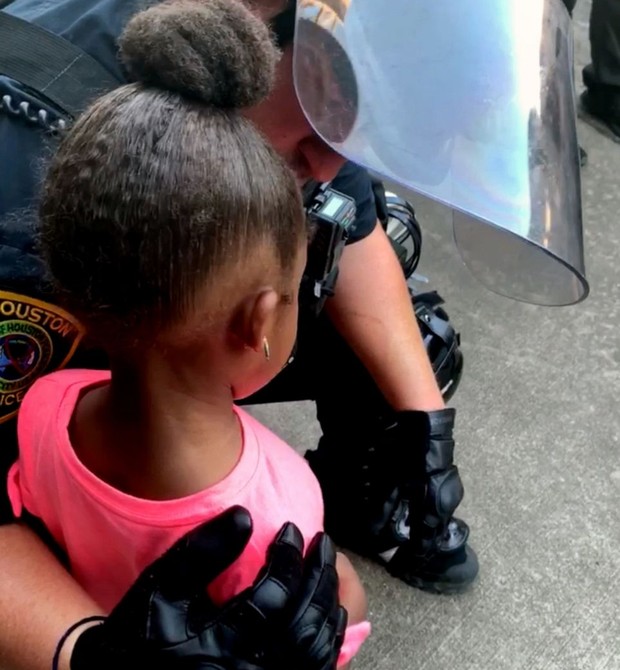 Policial conforta menina de 5 anos em protesto nos EUA (Foto: Reprodução/GMA)