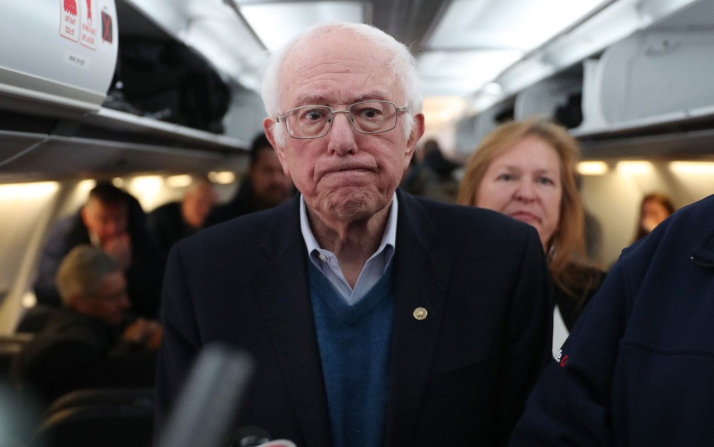 O pré-candidato democrata Bernie Sanders fala com jornalistas após embarcar no Aeroporto Internacional de Des moines, Iowa, com destino a New Hampshire, na terça-feira (4) — Foto: Joe Raedle/Getty Images/AFP