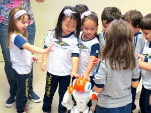 Alunas brincam com o robô Nao após a aula (Foto: Mariane Rossi/G1)