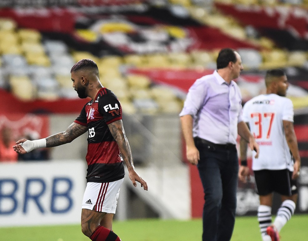 Gabigol abre os braços e reclama com Ceni, sem olhar para o treinador, que ouve de costas — Foto: André Durão