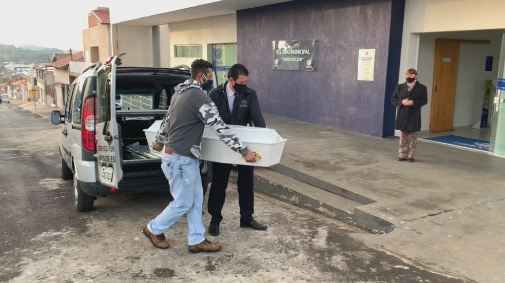 Pai de Carlos Henrique, morto depois de ser torturado por padrasto, ajuda a carregar o caixão do filho em Pardinho (SP) — Foto: Reprodução/ TV TEM 