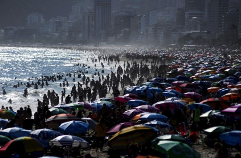 Onda de calor levou multidões à praia no Rio de Janeiro no dia 25 de janeiro. Calor provoca pico de consumo de água e desabastecimento em algumas cidades (Foto: Reuters via BBC News)