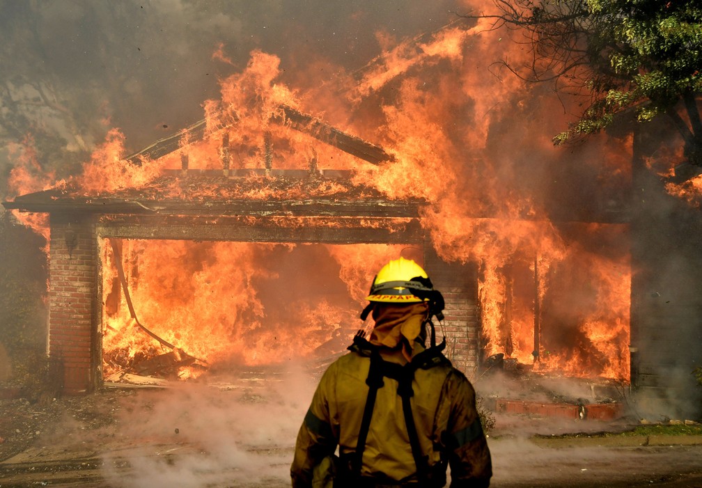 Bombeiros lutam para salvar uma das muitas casas que queimam no início da manhã, no vale de San Fernando, em Los Angeles, na Califórnia (Foto: Gene Blevins/Reuters)