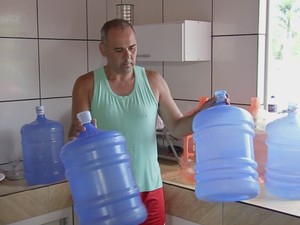 Empresário Reginaldo Pedro Florêncio precisou estocar galão de água (Foto: Reprodução/TVTEM)