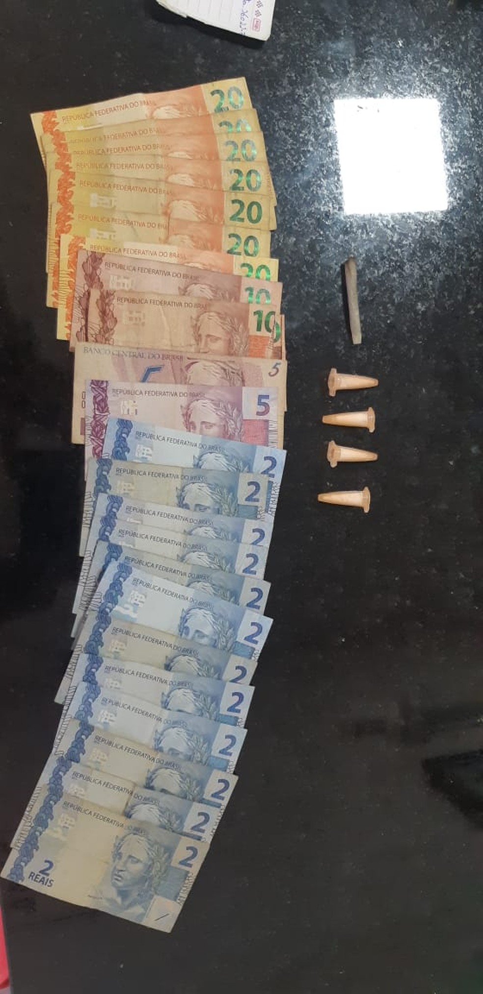 Com os suspeitos foram apreendidos dinheiro, pinos de cocaína e um cigarro de maconha  — Foto: Polícia Rodoviária / Divulgação 