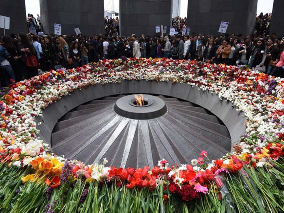 Pessoas depositam flores em memorial às vítimas dos massacres dos armênios em abril de 2015 em Yerevan — Foto: AFP PHOTO / KAREN MINASYAN