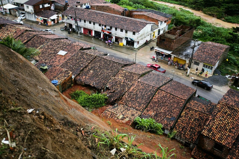 Casas que ficam ao pé da barreira foram parcialmente destruídas pelo deslizamento de terra — Foto: Jonathan Lins/G1