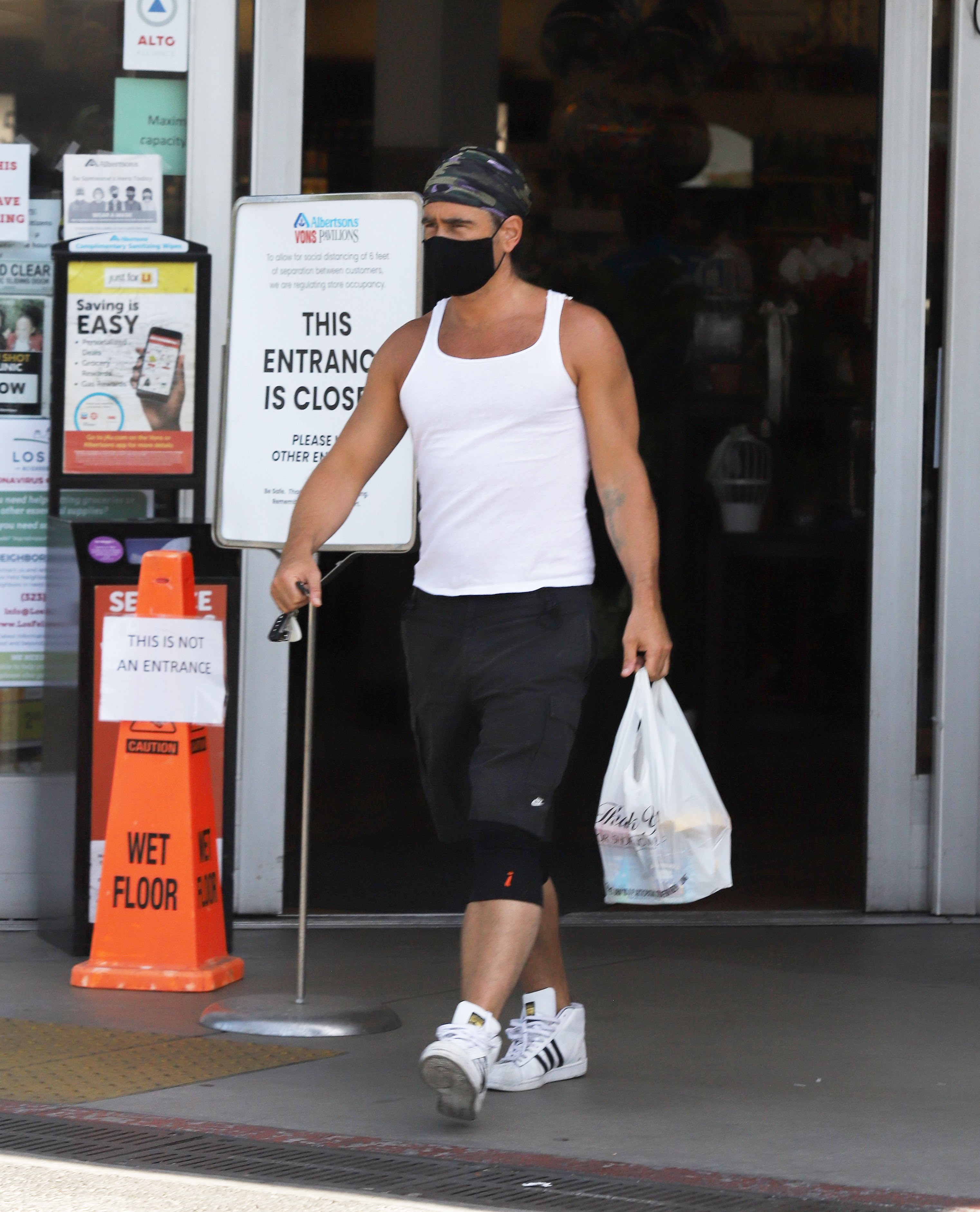 Colin Farrell vai às compras de máscara e regata, exibindo os braços agora sem tatuagens (Foto: The Grosby Group)