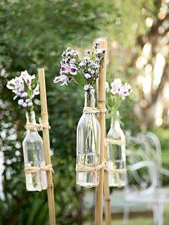 Para deixar o jardim com cara de festa, use garrafas com flores amarradas a bambus