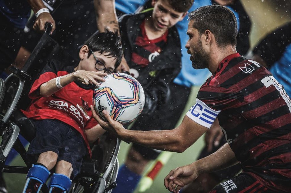 Diego hands the ball to little Gabriel in the match against Resende - Photo: Pedro Martins / Photo FC