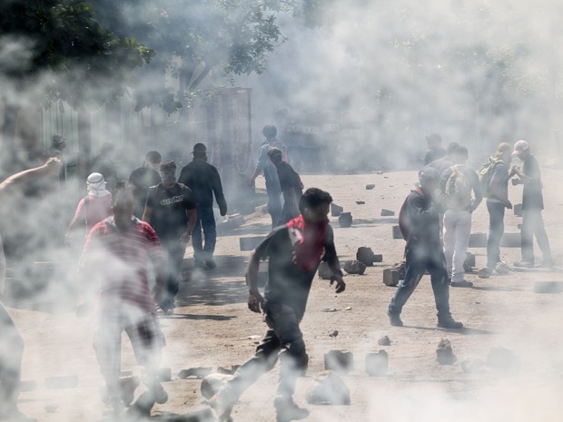 Manifestantes correm após a polícia lançar bombas de gás durante protestos de mineradores em greve em El Limon, na Nicarágua, na terça (6) (Foto: Eddy Lopez/La Prensa via AP)