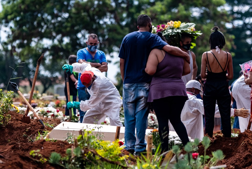 Funcionários usando roupas de proteção fazem o sepultamento de vítima da Covid-19 no Cemitério da Vila Formosa, na Zona Leste da capital paulista,. — Foto: Antônio Molina/Estadão Conteúdo/Arquivo