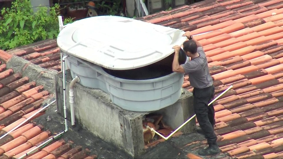 Agente vasculha caixa d'água na casa de Ronnie Lessa, na Barra — Foto: Reprodução/TV Globo