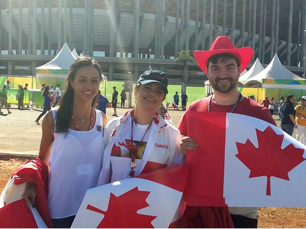 Funcionários da Embaixada do Canadá no Brasil distribuem bandeiras do país para o jogo no Mané Garrincha (Foto: Pedro Borges/G1)