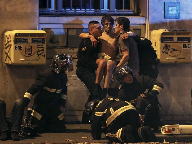 Equipe de resgate carrega um ferido perto da casa de espetáculos Bataclan, em Paris (Foto: Christian Hartmann/Reuters)