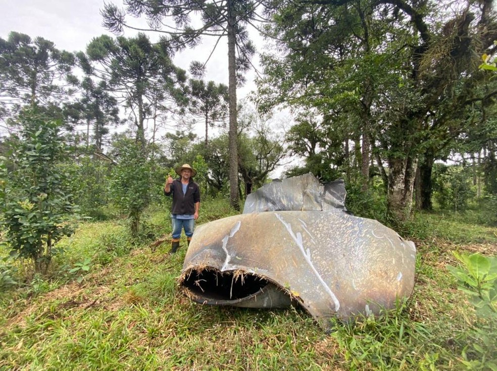 João Ricardo Pacheco Portes ao lado de peça metálica que ele acredita ser lixo espacial — Foto: Portal RDX/Reprodução