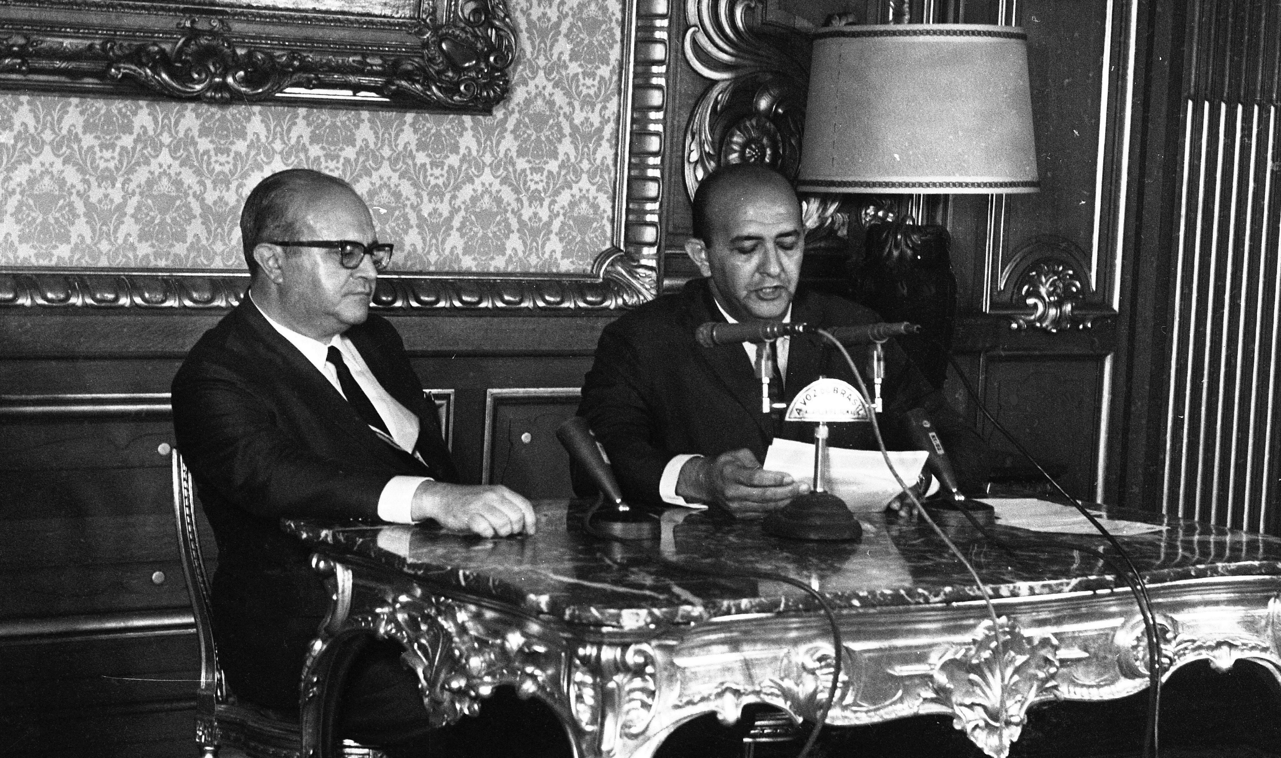 O ministro da Justiça, Luís Antônio Gama e Silva, ao lado do locutor Alberto Curi, durante leitura do AI-5