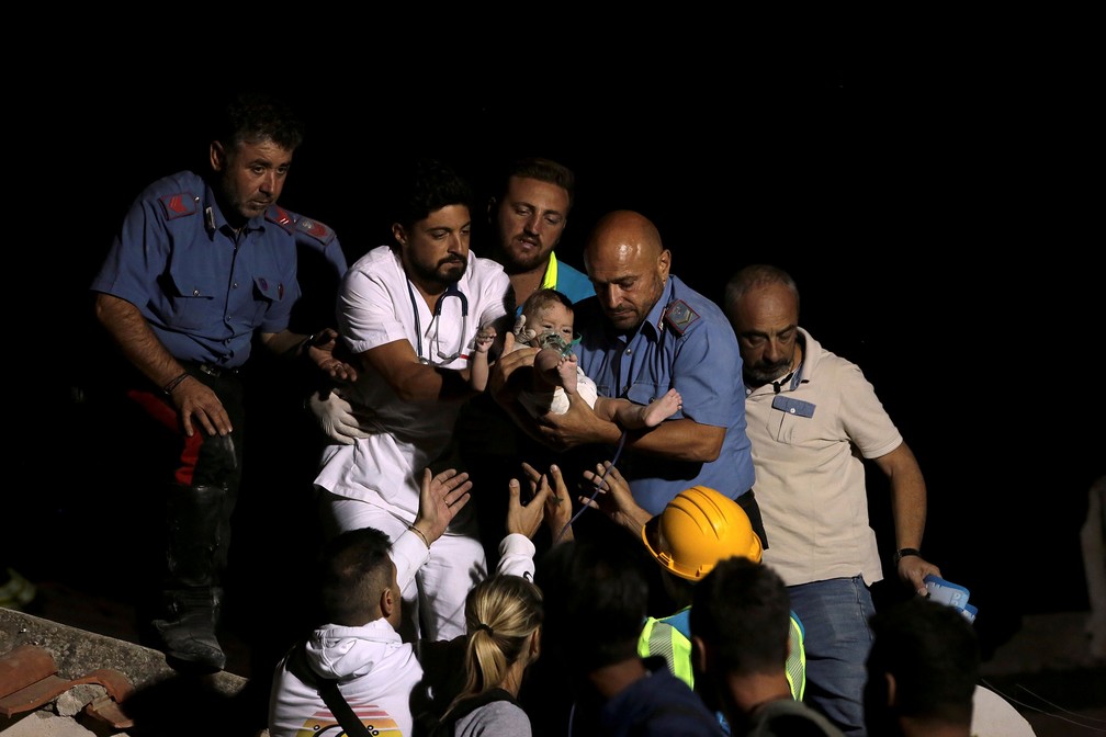 Resgatistas retiraram bebê de escombros nesta terça-feira (22) na ilha de Isquia, na Itália   (Foto: Antonio Dilaurenzo/Reuters)