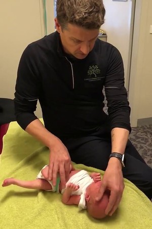 O profissional dá tapinhas na cabeça do bebê (Foto: Reprodução Youtube)