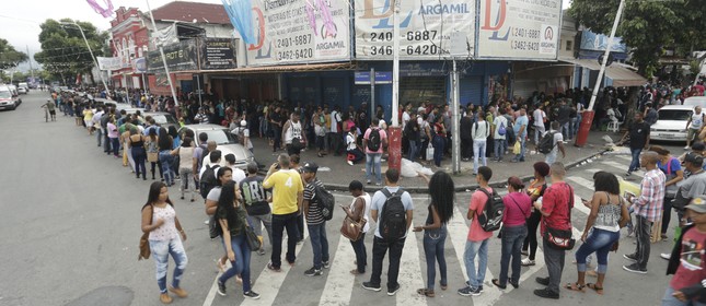 Na imagem, fila do emprego faz a curva