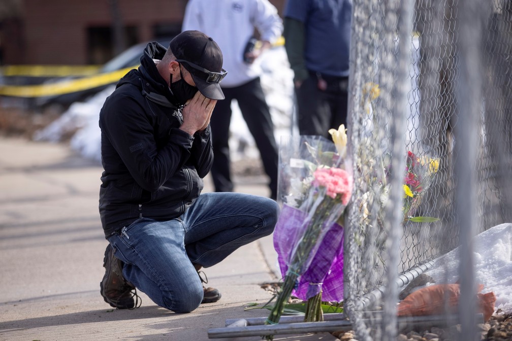 Americano deixa flores em homenagem a vítimas de massacre no Colorado, nos EUA, em 23 de março — Foto: Alyson McClaran/Reuters