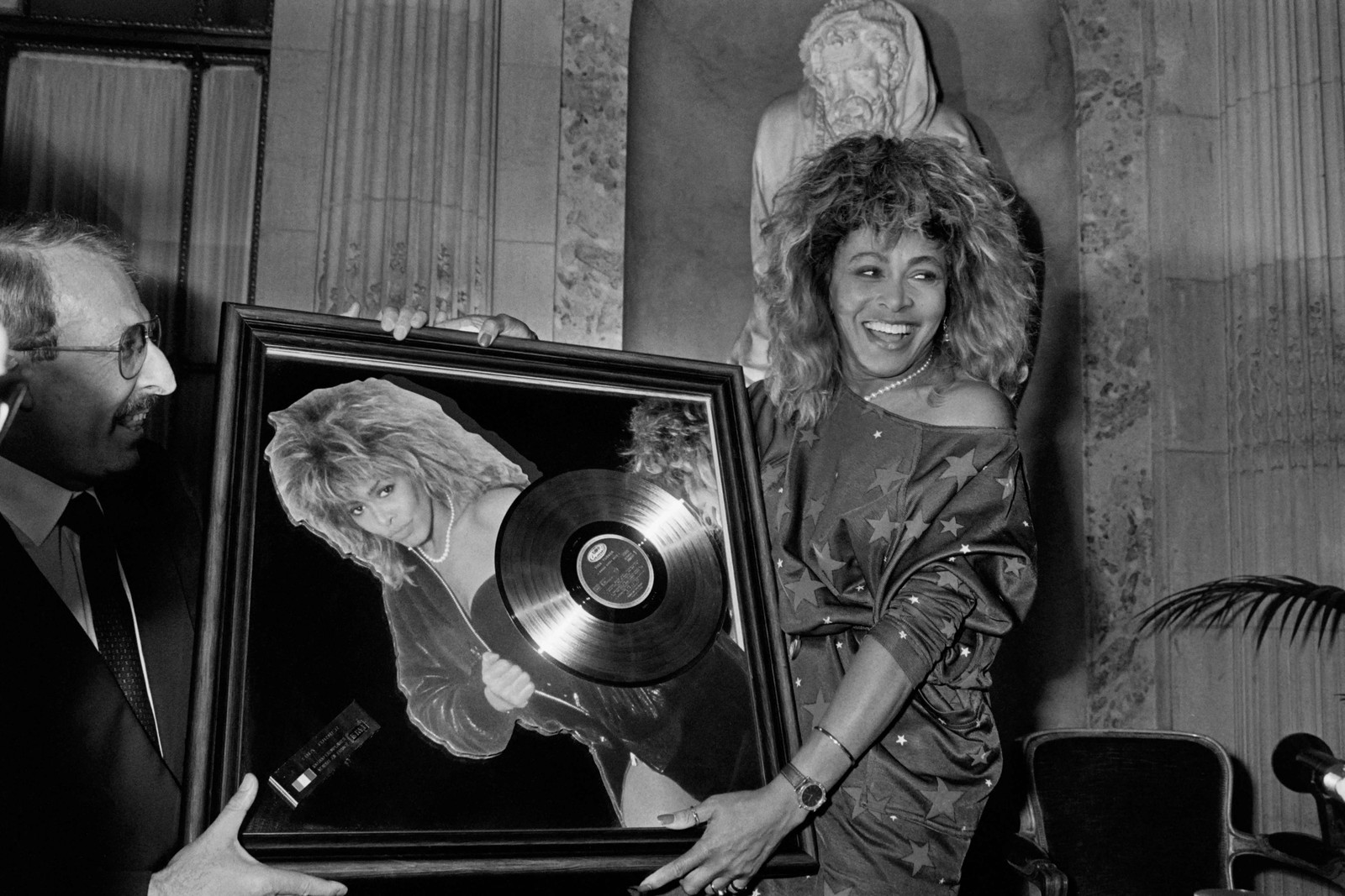 A cantora norte-americana Tina Turner recebe o Disco de Ouro das mãos do presidente da Pathé Marconi, Guy Deluz (à esquerda), em 8 de outubro de 1986, em Paris. — Foto: Georges BENDRIHEM / AFP