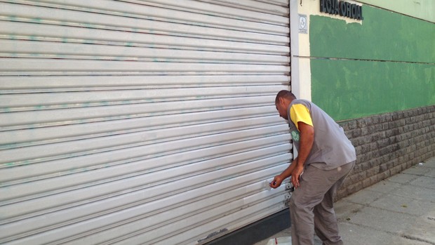 Funcionário pinta porta da loja do Palmeiras, que estava pichada (Foto: Sergio Gandolphi / Globoesporte.com)