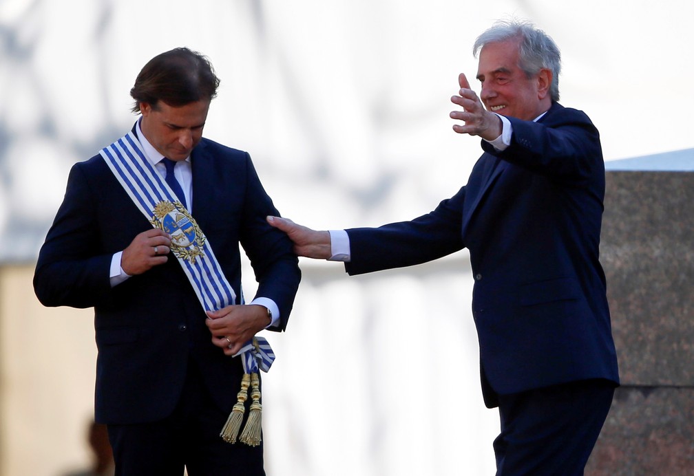Luis Lacalle Pou recebe a faixa presidencial de Tabaré Vázquez ao tomar posse como presidente do Uruguai neste domingo (1º) — Foto: Mariana Greif/Reuters