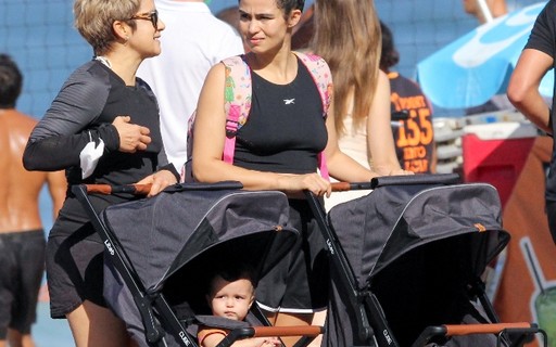 Nanda Costa e Lan Lanh passeiam com as filhas em orla de praia no Rio