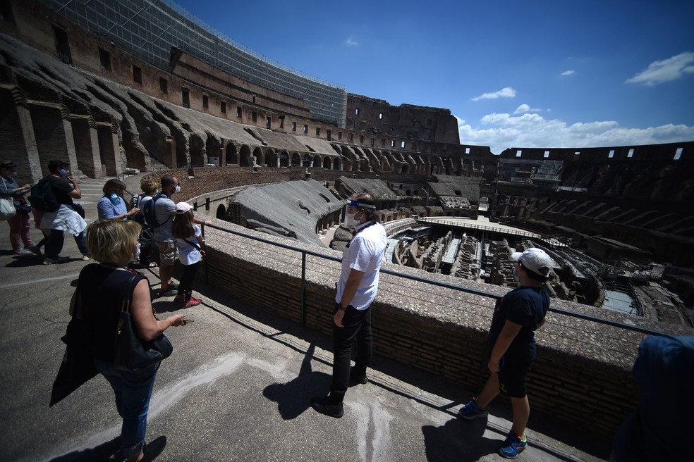 Guia conduz visita no Coliseu, em Roma, que foi reaberto nesta segunda-feira (1º)  — Foto: Filippo Monteforte / AFP
