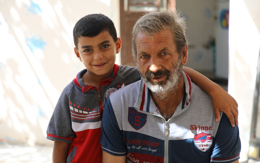  O refugiado sírio Abdul Hameed e seu neto Odai são vistos do lado de fora de sua casa em Amã, na Jordânia, onde Odai vive desde que nasceu — Foto: ACNUR/Lilly Carlisle