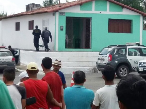 Casa onde o homem atirou na própria mãe está cercada pela polícia (Foto: PM/Divulgação)