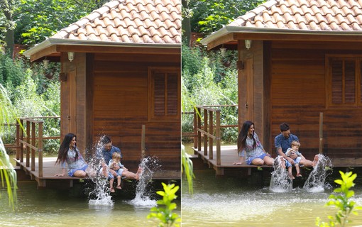 Família se diverte em lago em volta da casa de madeira