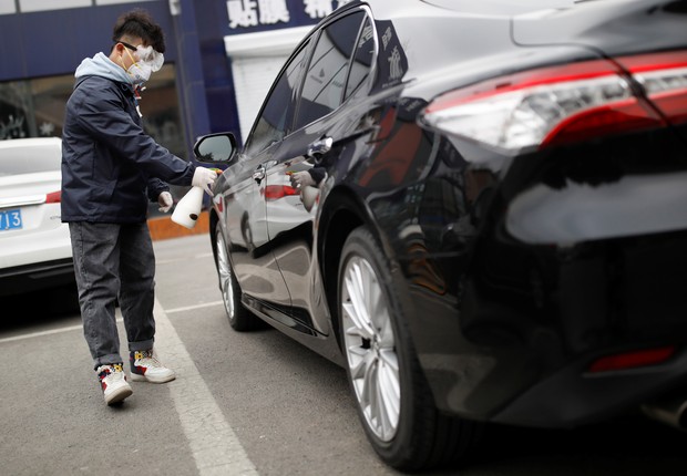 Homem desinfeta carro em Pequim   (Foto: REUTERS/Carlos Garcia Rawlins)