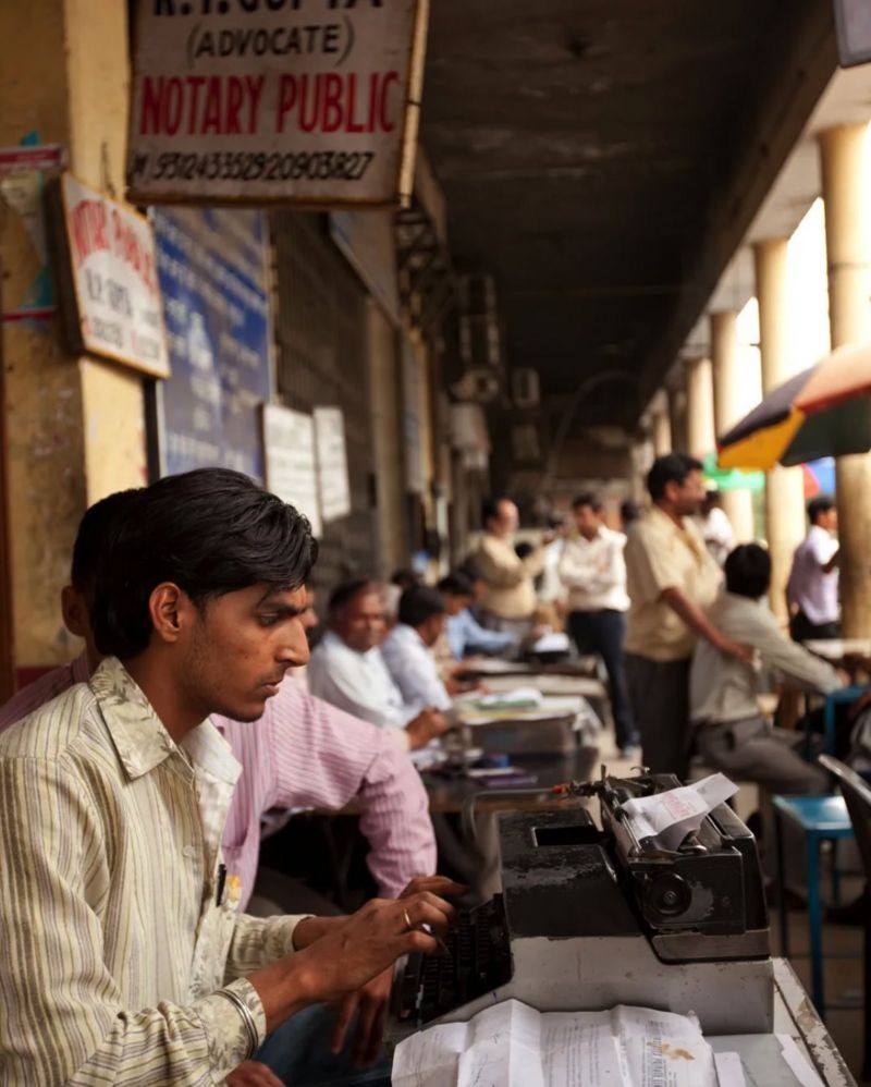 Ainda há um grande número de datilógrafos na Índia, que se sentam do lado de fora dos escritórios jurídicos e batem anotações de processos em suas máquinas de escrever (Foto: ALAMY via BBC News)
