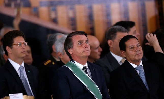 O vice-presidente Hamilton Mourão (à direita) com Bolsonaro e o ministro Ricardo Salles: isolado das conversas sobre o clima