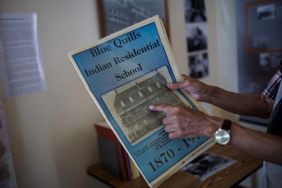 Eric Large, ex-chefe da Saddle Lake First Nation e sobrevivente da Blue Quills Indian Residential School, mostra fotos de arquivo da atual Universidade nuhelt'ine tahiyots'i nistameyimakanak Blue Quills em St Paul, Alberta, Canadá