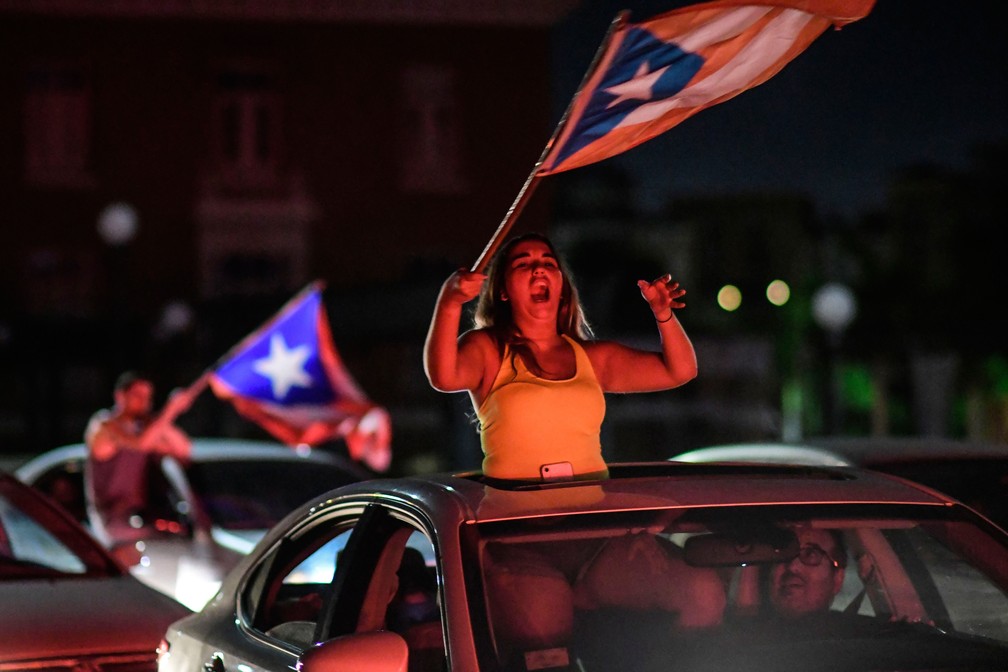 Mulher agita bandeira de Porto Rico após anúncio da renúncia do governador Ricardo Rossello  — Foto: Carlos Giusti/AP