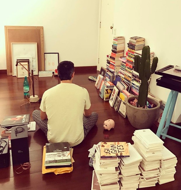 Pedro Neschling entre pilhas de livros antes da mudança (Foto: Reprodução/Instagram)