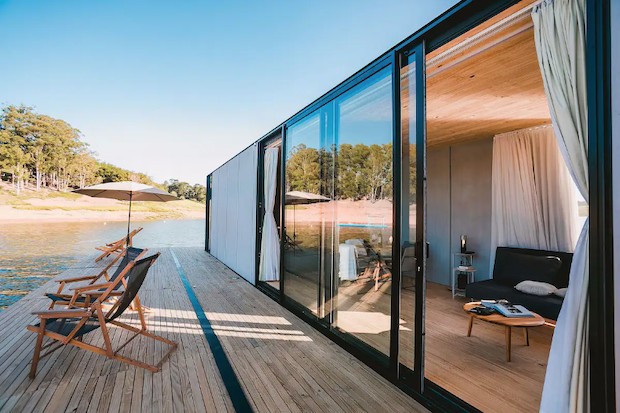 O deque exterior é um convite ao relaxamento e descompressão, com cadeiras de praia e ombrelone (Foto: Airbnb / Divulgação)
