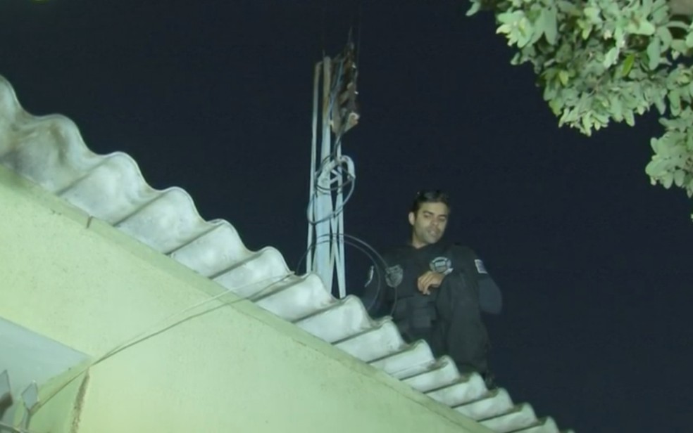 Policial vistoria rede de energia de casa em Birigui (Foto: Reprodução/TV TEM)