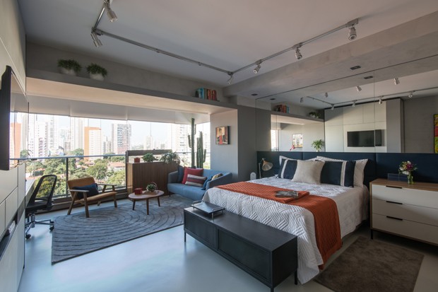 Apartamento de 39 m² com estilo industrial tem sala de estar na varanda (Foto: Divulgação)