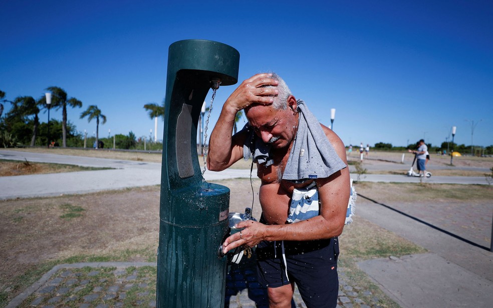 Homem se refresca às margens do Rio de la Plata, durante onda de calor em Buenos Aires, no domingo (9) — Foto: Reuters/Agustin Marcarian 