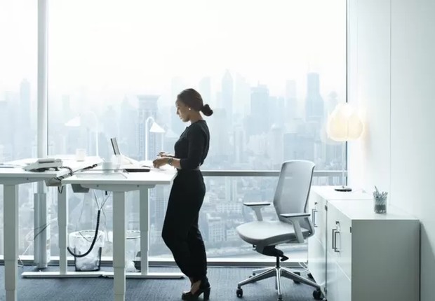 Que tal usar uma mesa com altura regulável e trabalhar em pé? (Foto: GETTY IMAGES)