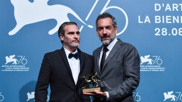 Todd Phillips (à direita) e Joaquin Phoenix receberam o Leão de Ouro no festival de Veneza (Foto: AFP VIA BBC )