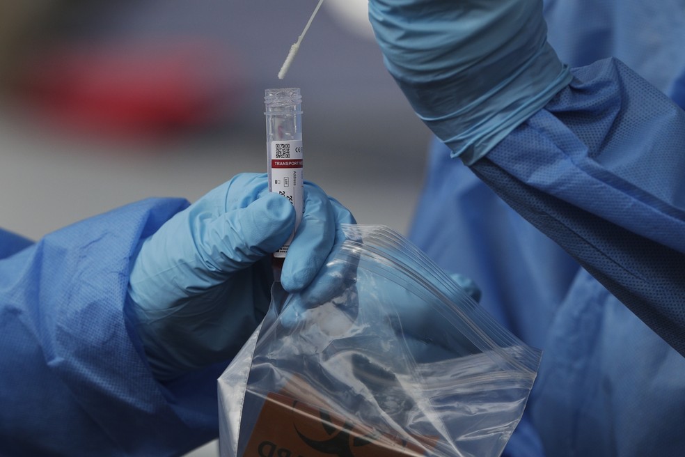 Profissionais de saúde guardam swab em tubo após coletar amostra do nariz para teste de Covid-19, no Panamá, no dia 15 — Foto: Arnulfo Franco/AP